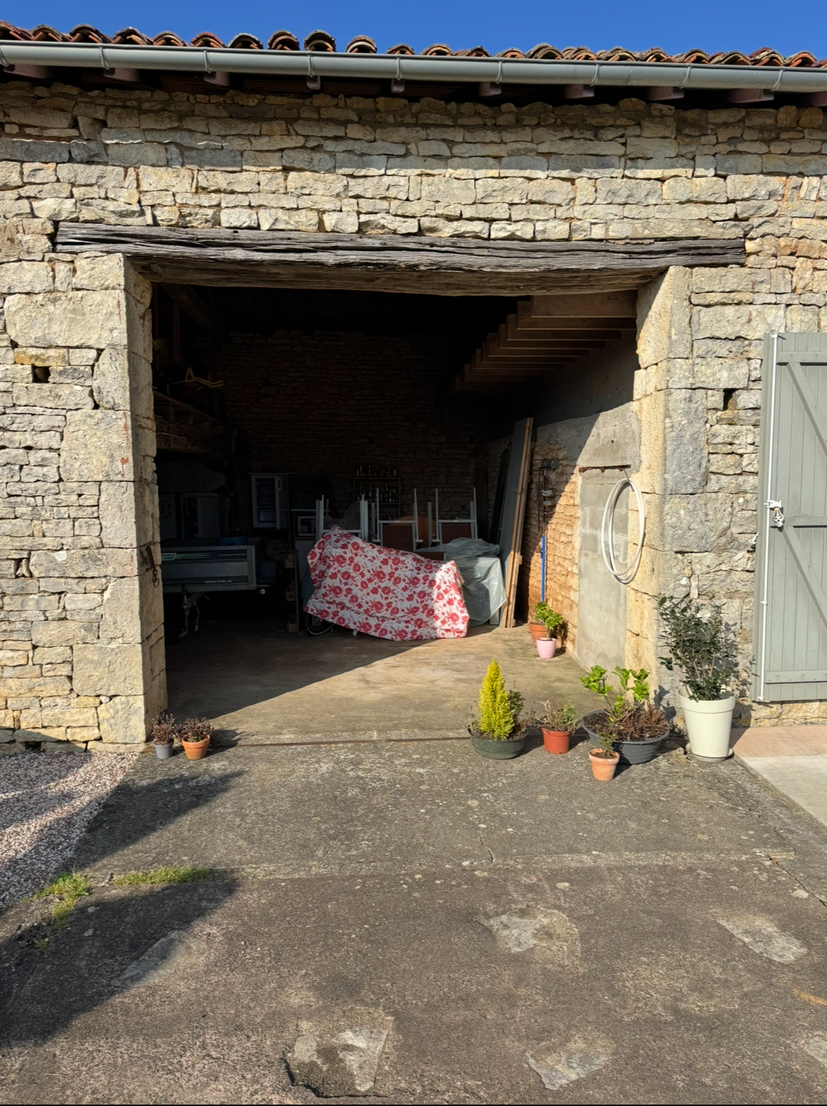 Ouverture de grange en pierre avant la pose d’une porte en bois exotique à Brux.