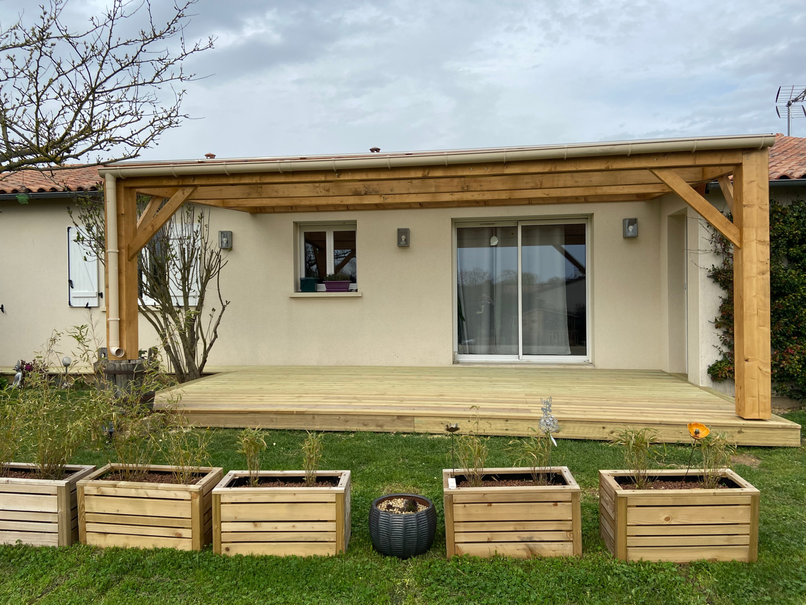 Terrasse en bois avec pergola adossée et toiture translucide