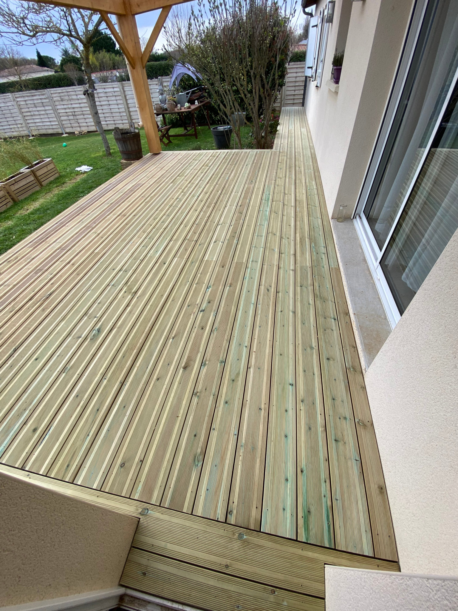 Terrasse en lames de bois posée le long de la façade