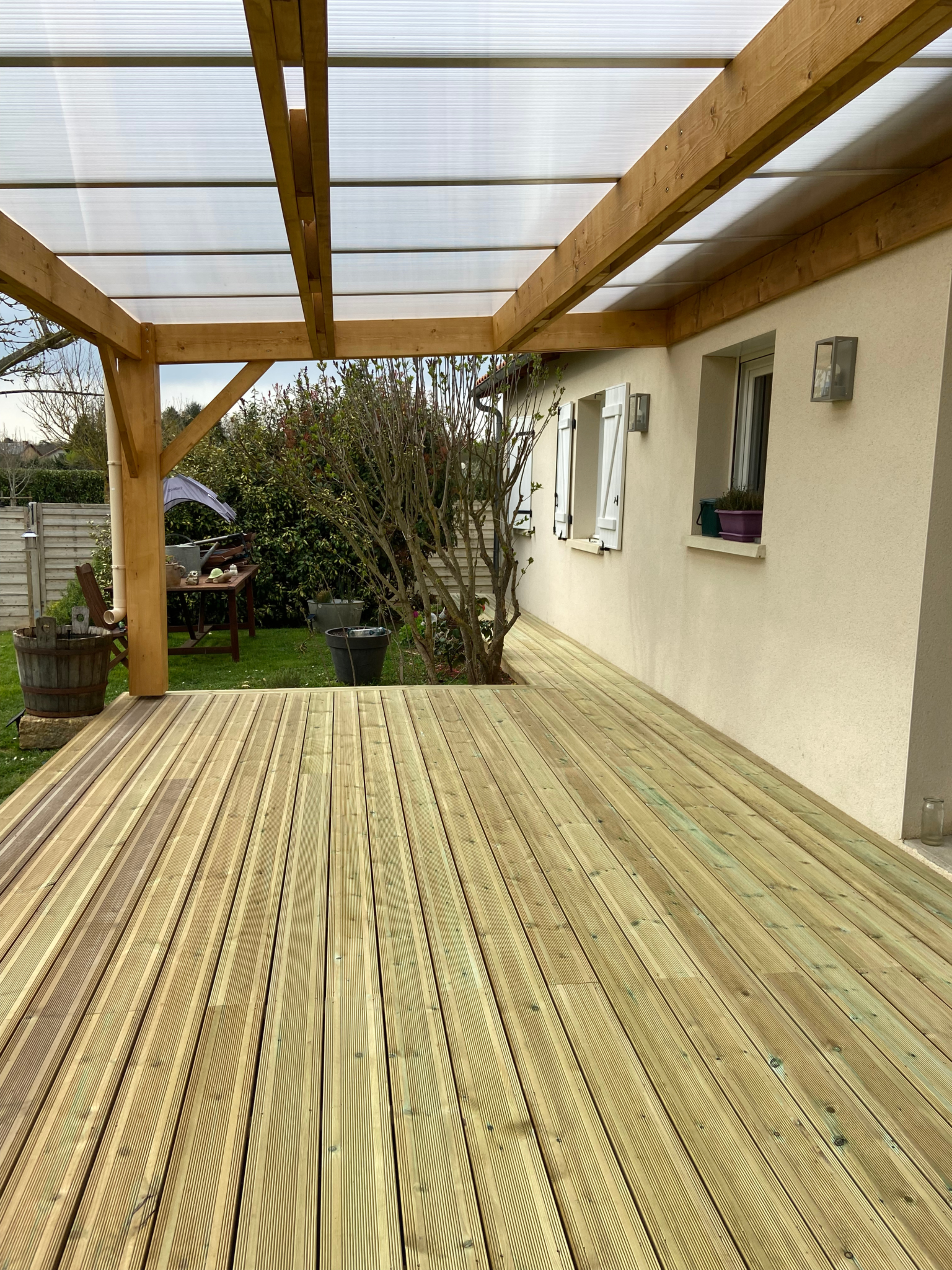 Vue intérieure d’une pergola en bois avec couverture translucide